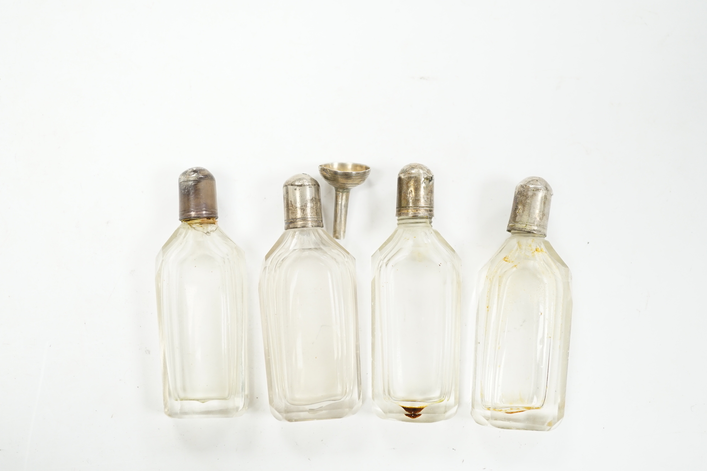 A set of four Dutch white metal mounted scent bottles, with funnel, housed in a shagreen case with hinged cover, case height 69mm.